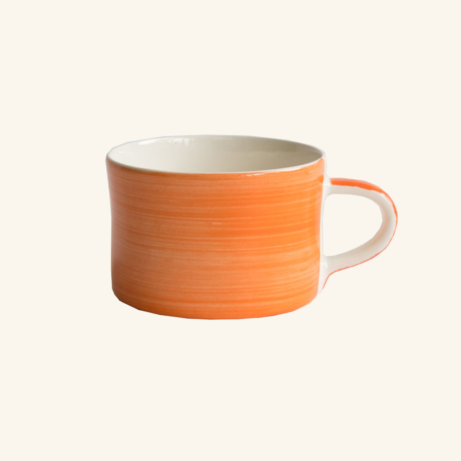 A large ceramic mug with a red and beige color wash design and a white handle.