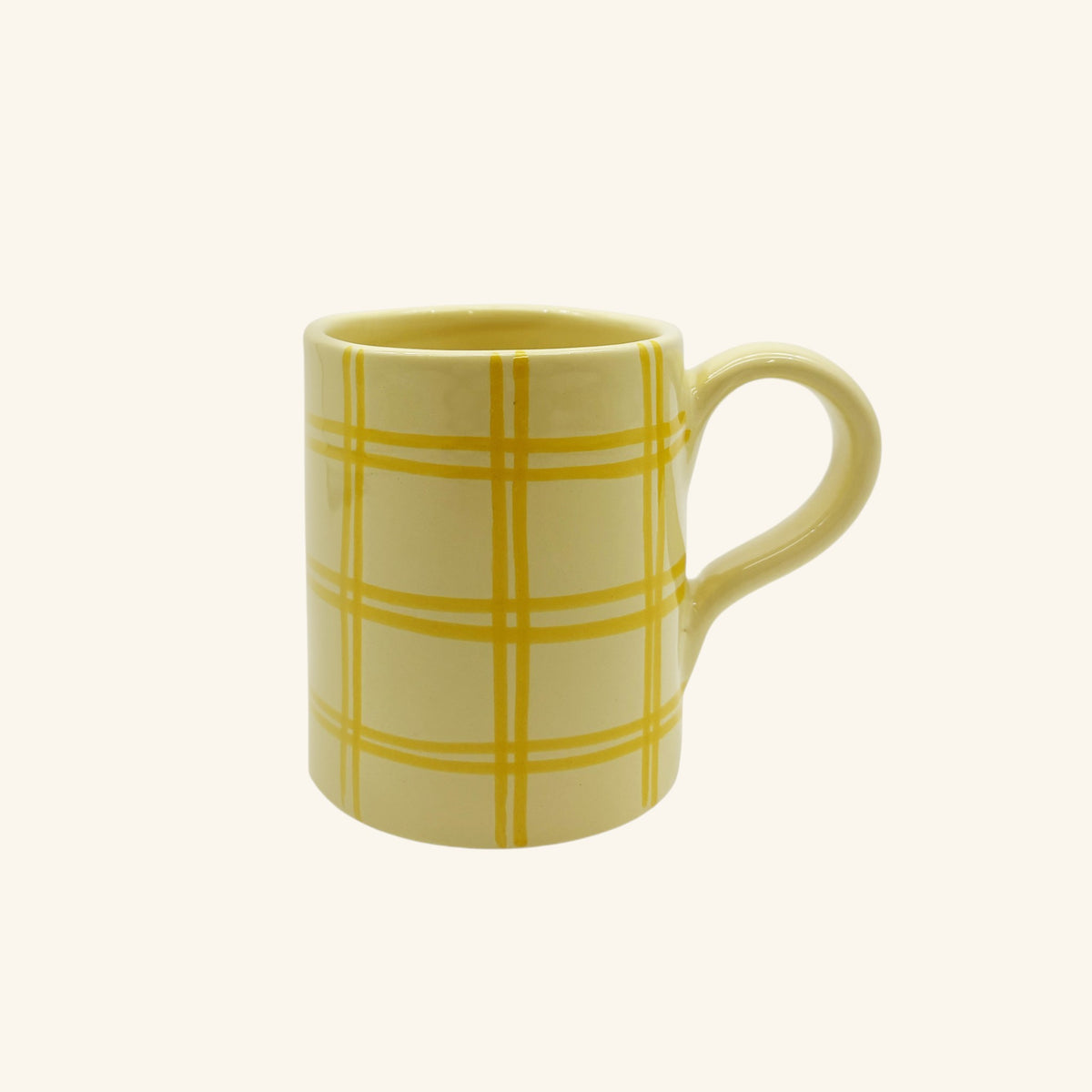 Yellow mug with plaid pattern on a white background