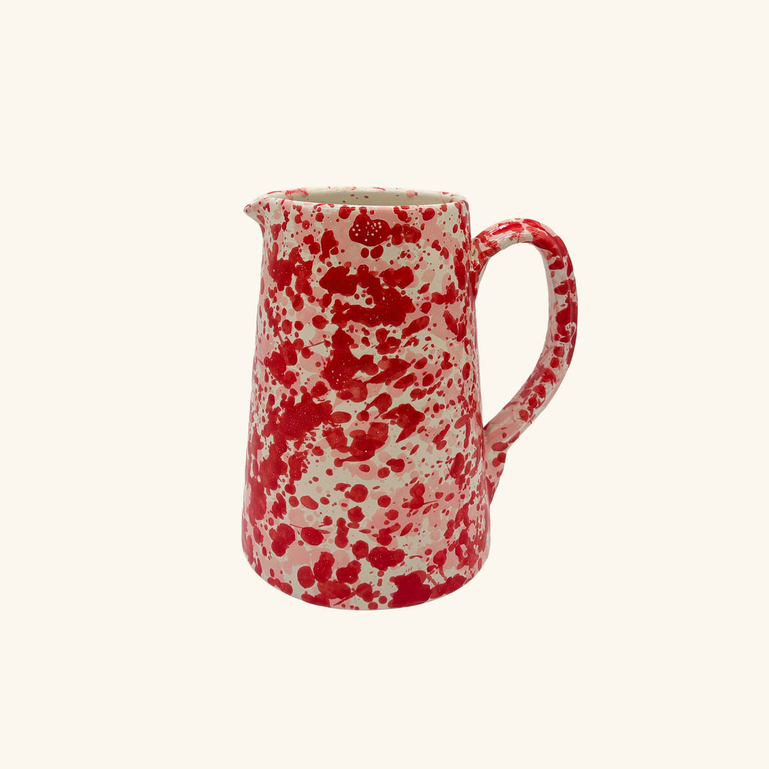 Red and white speckled ceramic pitcher on a white background