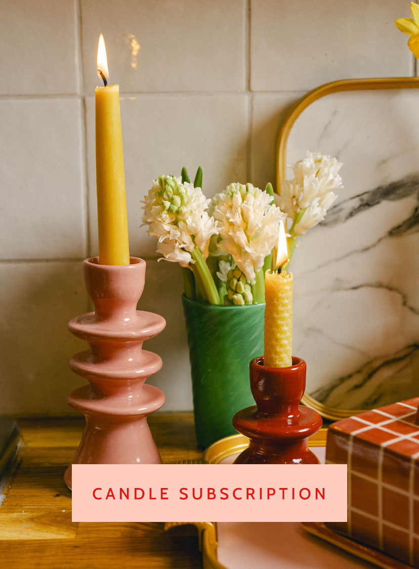 Candle and flower arrangement on a kitchen worktop with marble tray, featuring text 'CANDLE SUBSCRIPTION'. LAMP LDN LIVING